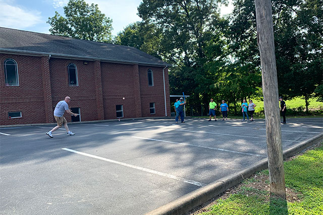 Playing baseball in the parking lot.