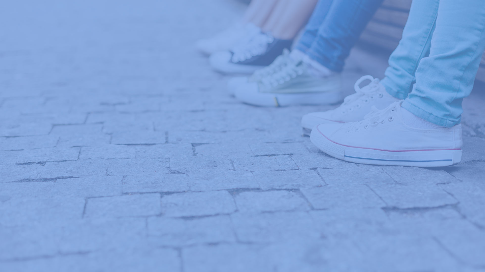 Teens sitting on a curb.